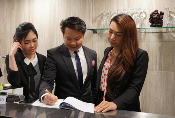Three young professionals who are nicely dressed looking at the accounts as part of their student jobs. Vaia Magazine